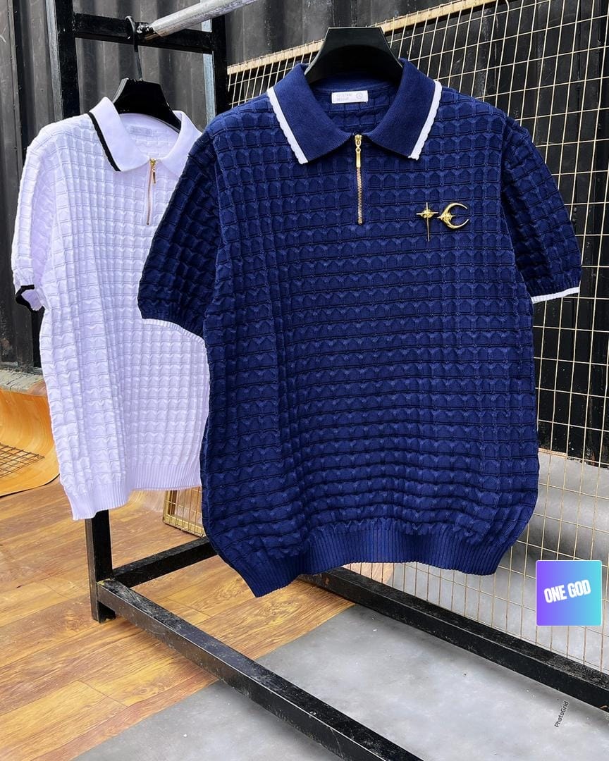 Navy and white textured knit zip polo shirts on clothing rack.
