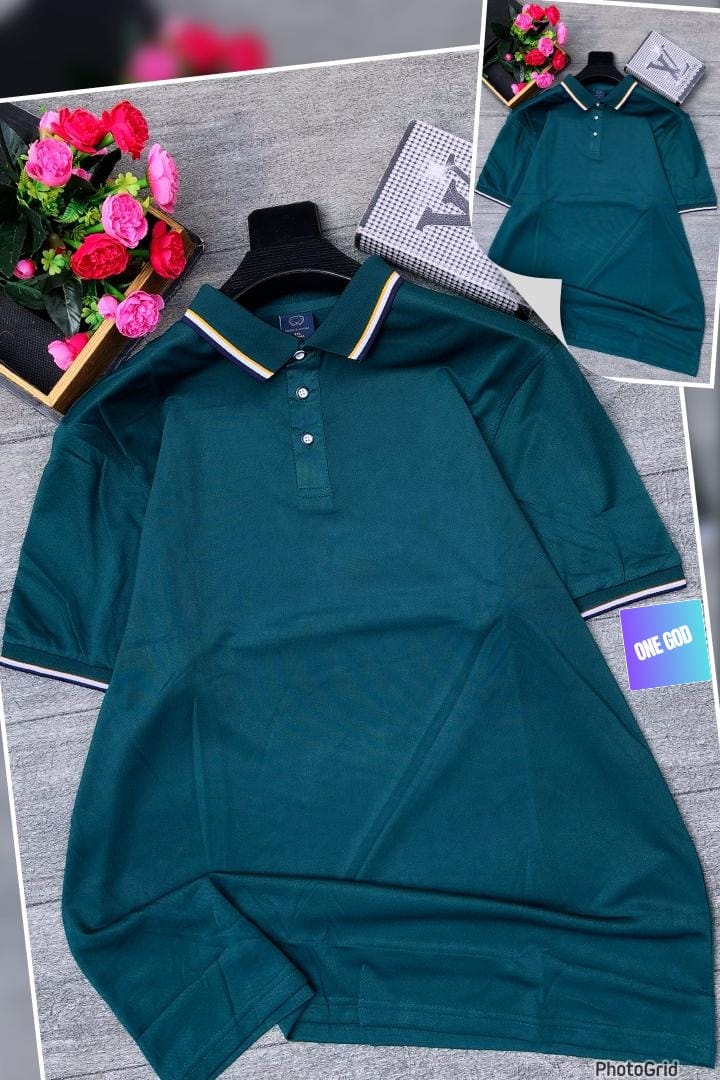 Dark green polo shirt with contrast striped collar trim displayed on gray surface with floral arrangement.