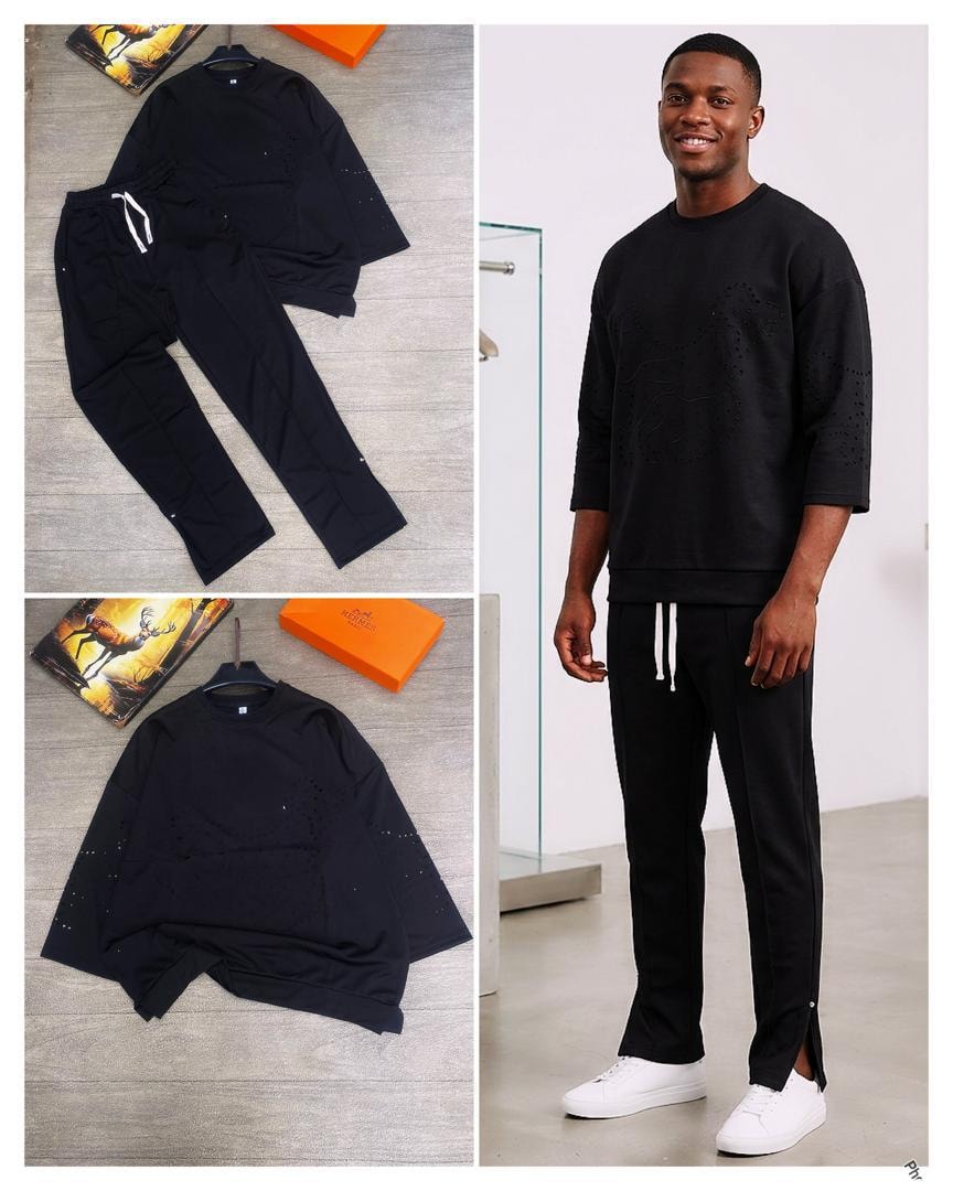 Black perforated sweatshirt and jogger two-piece set worn by smiling model.