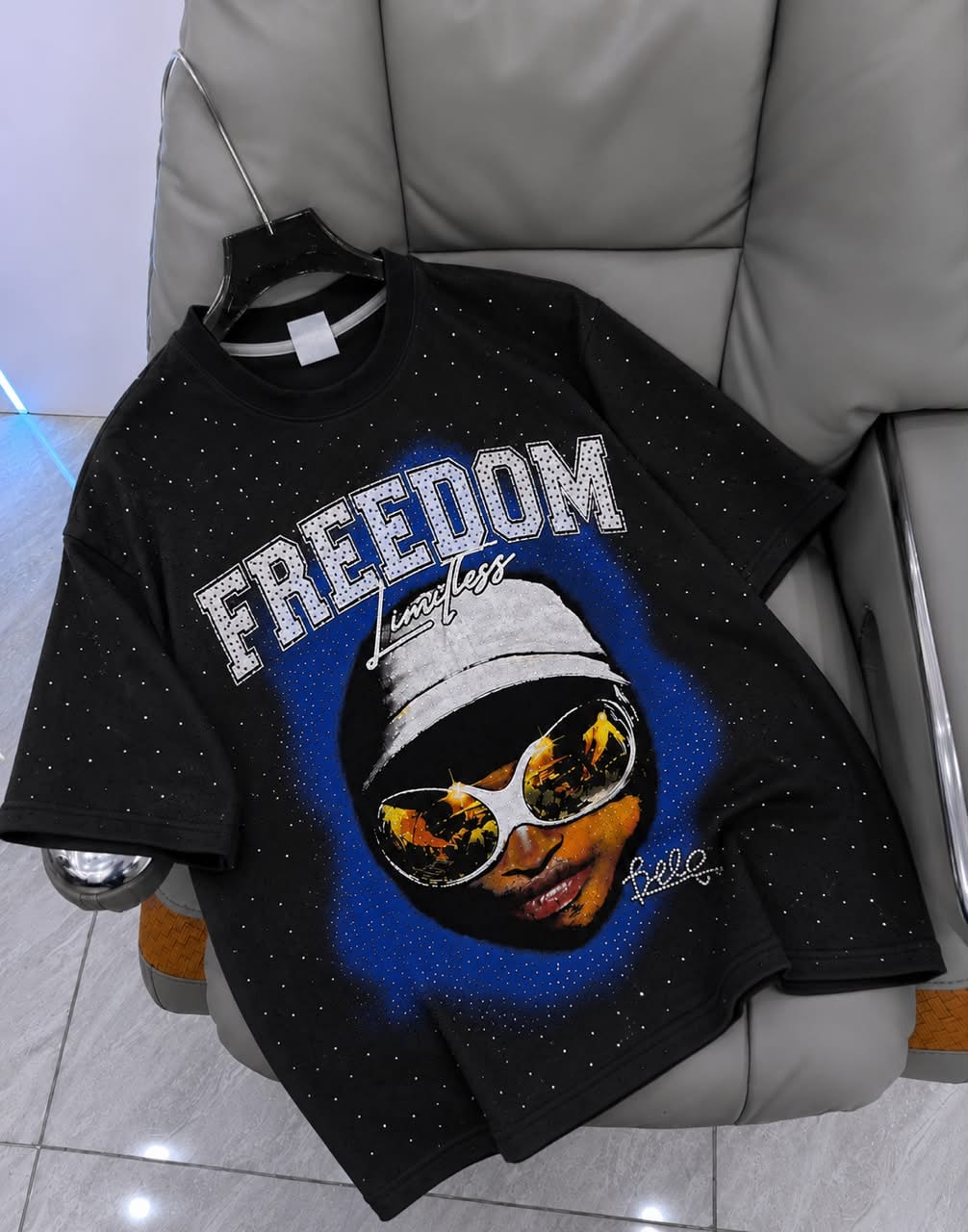 Black rhinestone graphic t-shirt with FREEDOM portrait design on hanger.