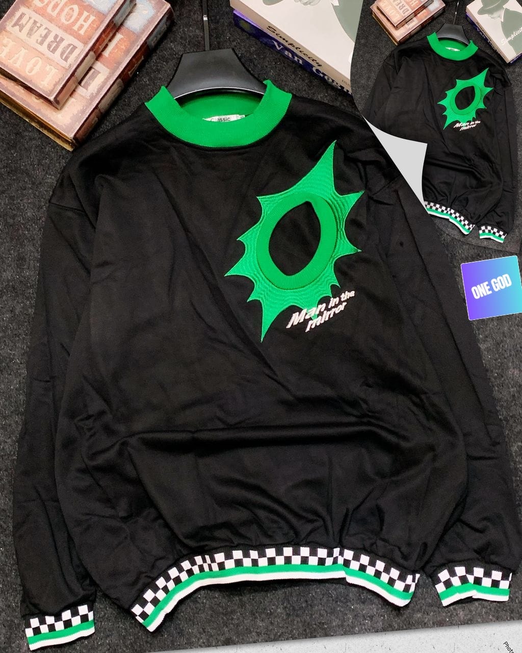 Black Man in the Mirror sweatshirt with green embroidered logo and checkered trim.