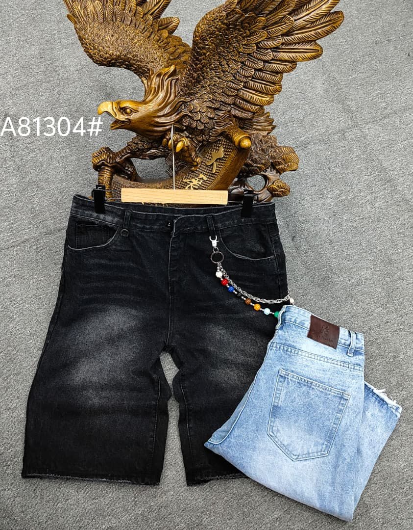 Black baggy jorts with colorful chain accessory displayed with folded light blue pair and eagle statue.
