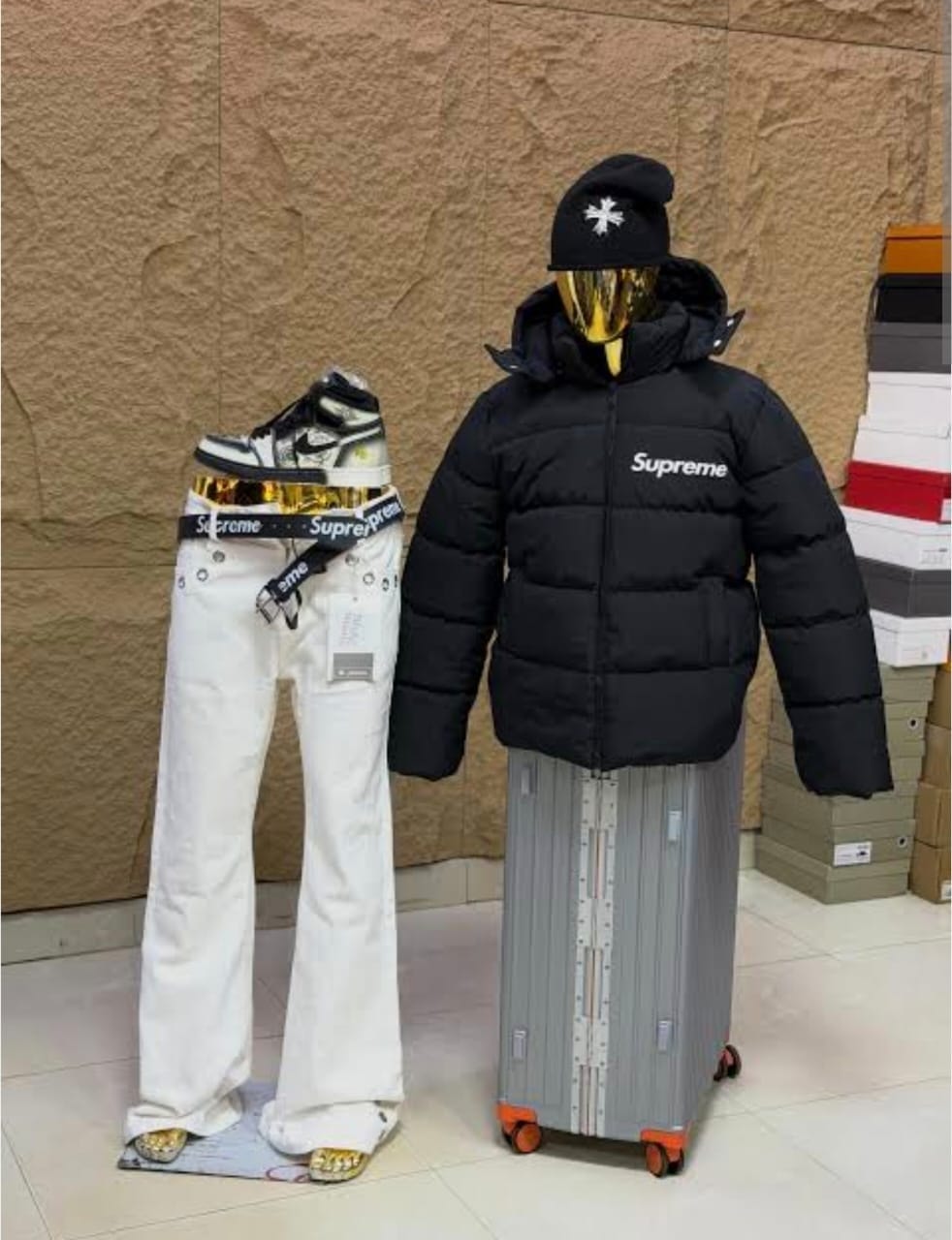 Black Supreme puffer jacket and white baggy pants front view on mannequin.