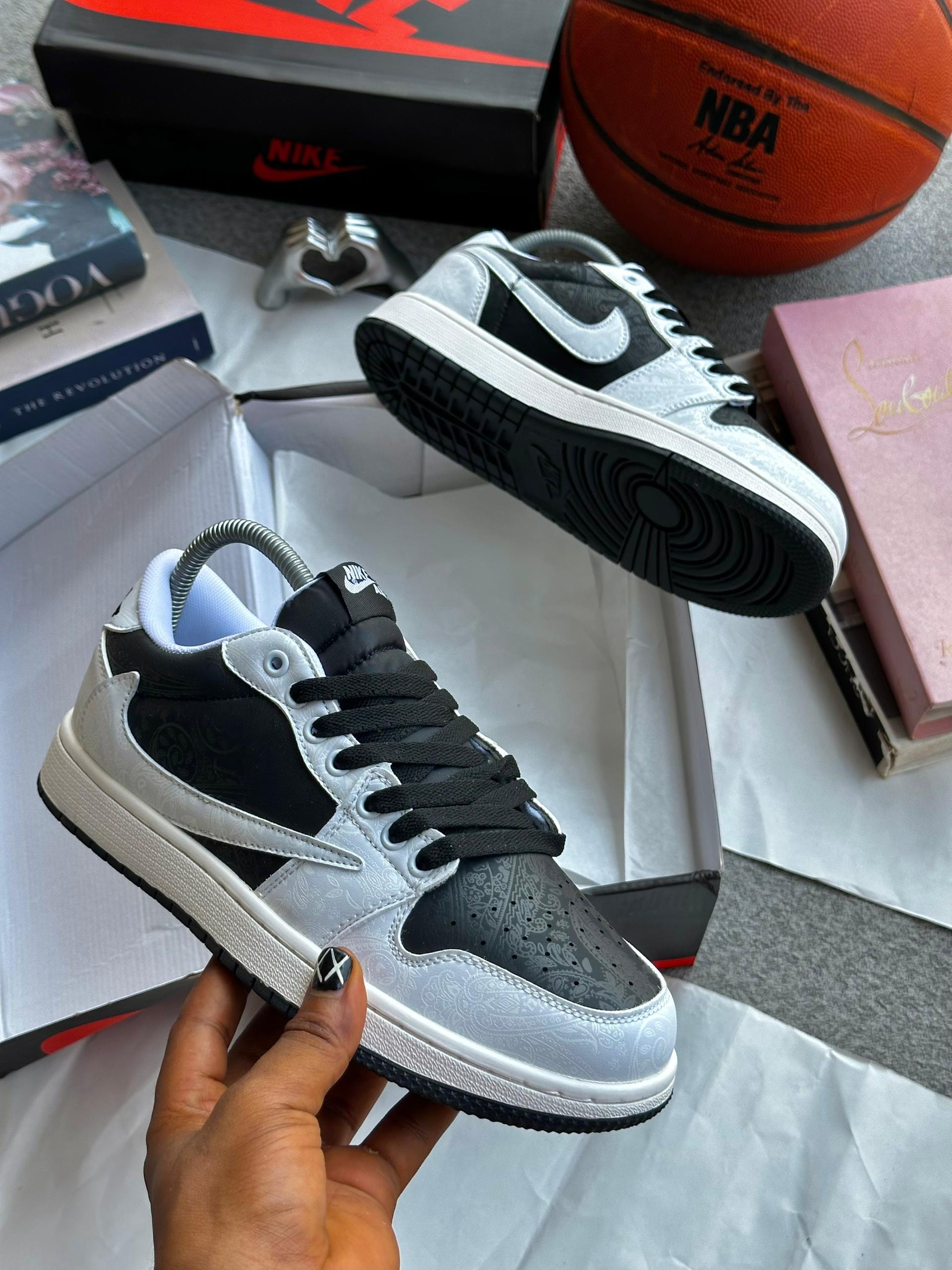 Nike Air Jordan 1 with paisley pattern in black white and grey held by hand with Nike box.