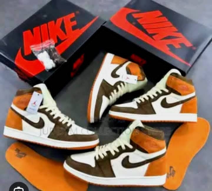 Multiple Nike Air Jordan 1 High sneakers in brown white and orange with boxes and insoles.