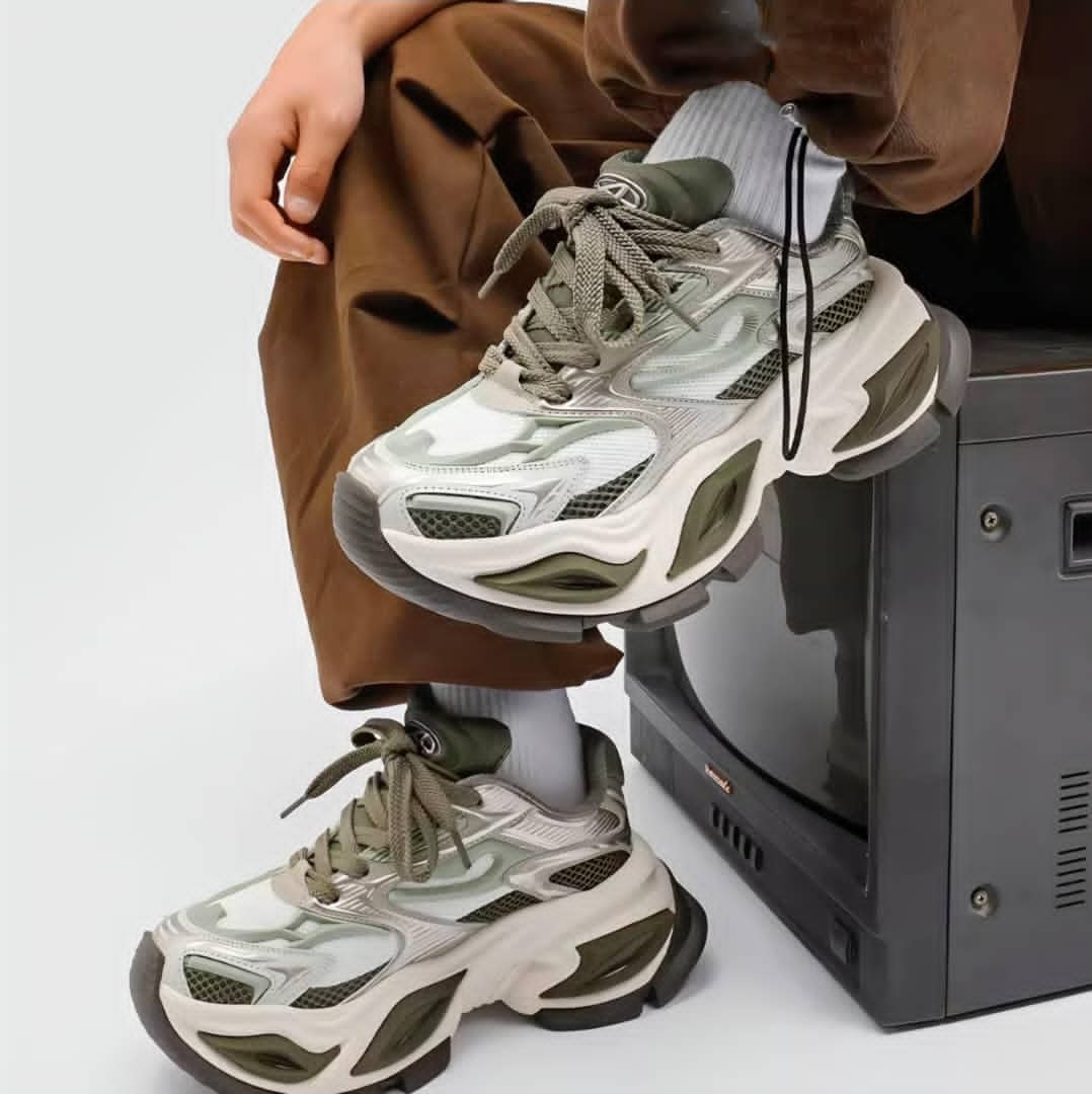 Person wearing green and beige Balenciaga Runner chunky sneakers in studio setting.