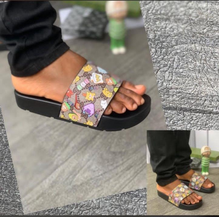 Person wearing brown cartoon character platform slides with close-up of textured sole.
