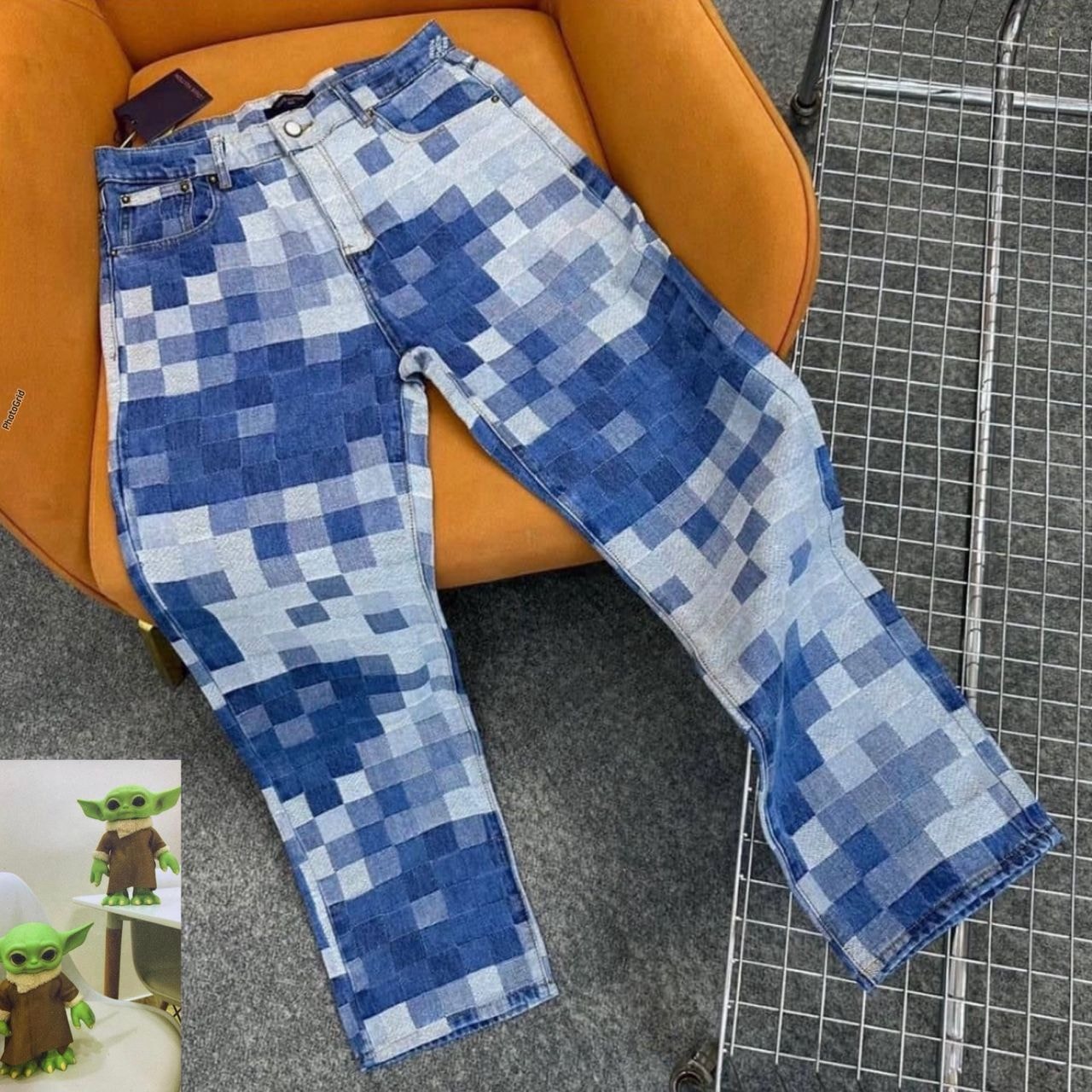 Blue pixelated patchwork pattern baggy jeans displayed on orange chair with flat lay view.