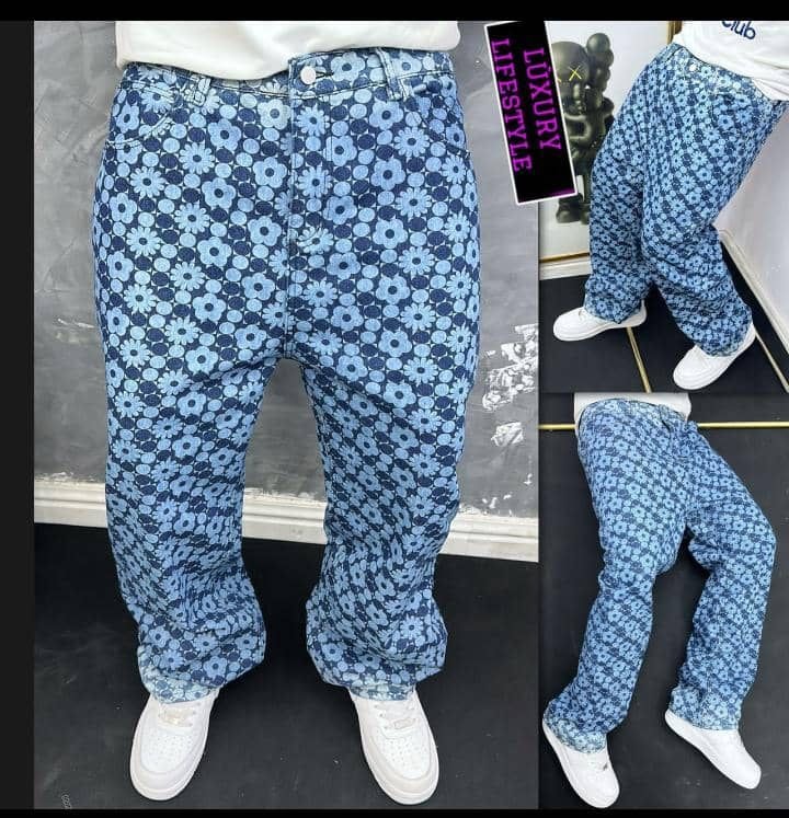 Person wearing blue floral daisy pattern baggy jeans shown in multiple angles with white sneakers.