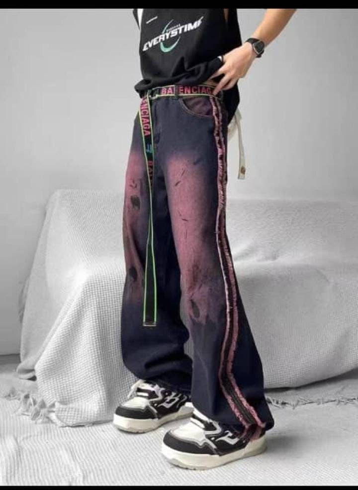 Model wearing dark purple gradient baggy jeans with pink side stripe and statement belt.