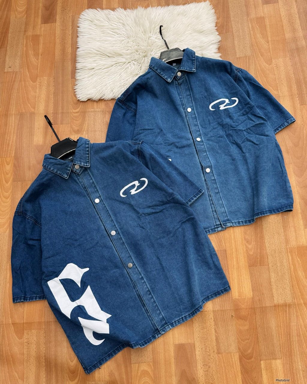 Blue denim short sleeve button-up shirt with white graphic prints shown from multiple angles on wooden floor.