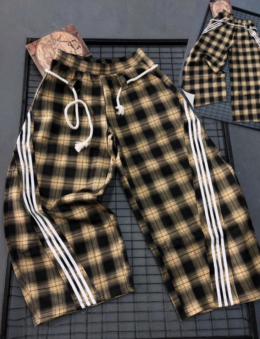 Brown plaid joggers with white drawstring and side stripes laid flat.