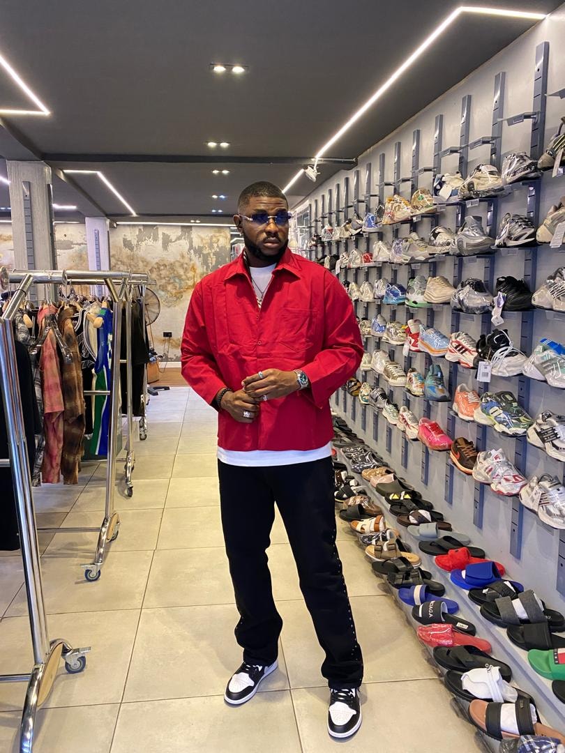 Man wearing red embroidered long sleeve shirt in retail store