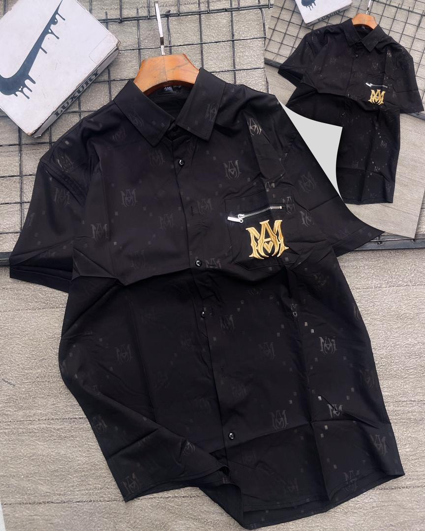 Black MM monogram short sleeve shirt with gold embroidery on zip pocket.