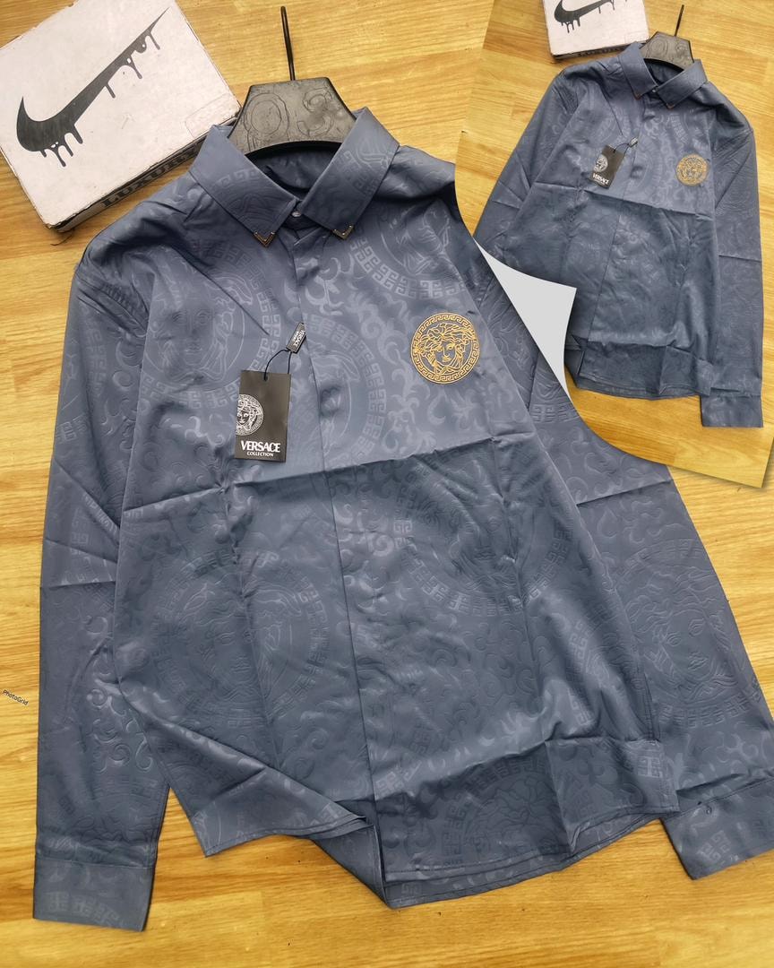 Blue Versace all-over print long sleeve shirt displayed with hanger and brand tags.