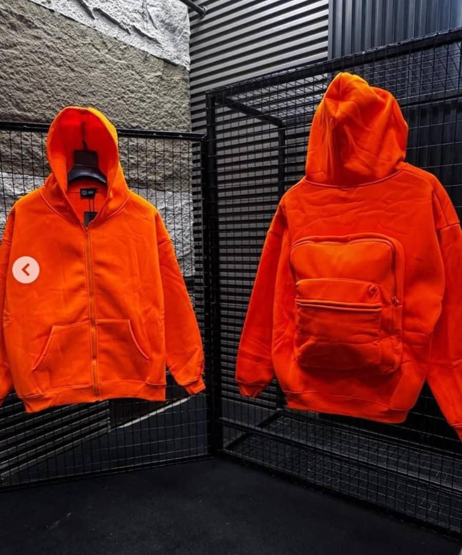 Front and back views of orange zip-up hoodie with front pocket and large quilted back pouch.