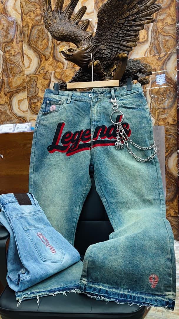 Blue baggy jeans with Legends embroidery, chain accessory, and folded back view detail.