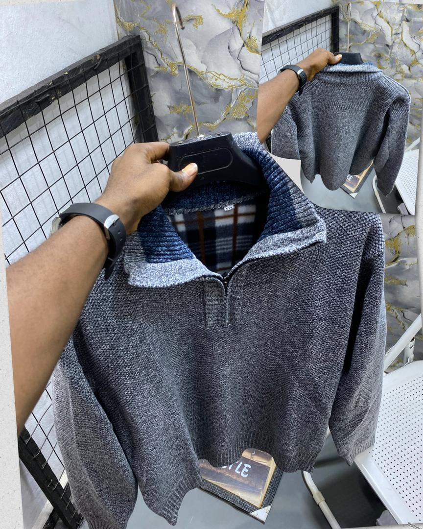 Gray textured knit quarter-zip sweatshirt on hanger with visible striped collar and plaid lining.