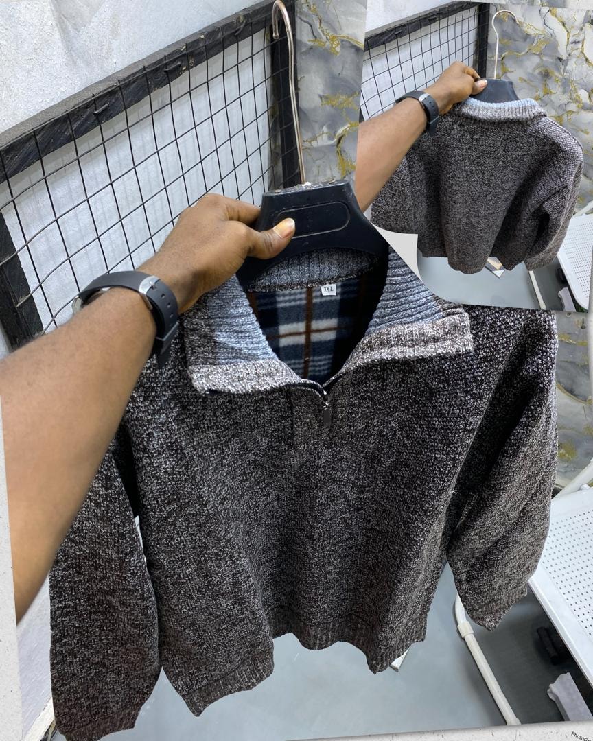 Gray textured knit quarter-zip sweatshirt on hanger with striped collar and plaid lining visible.