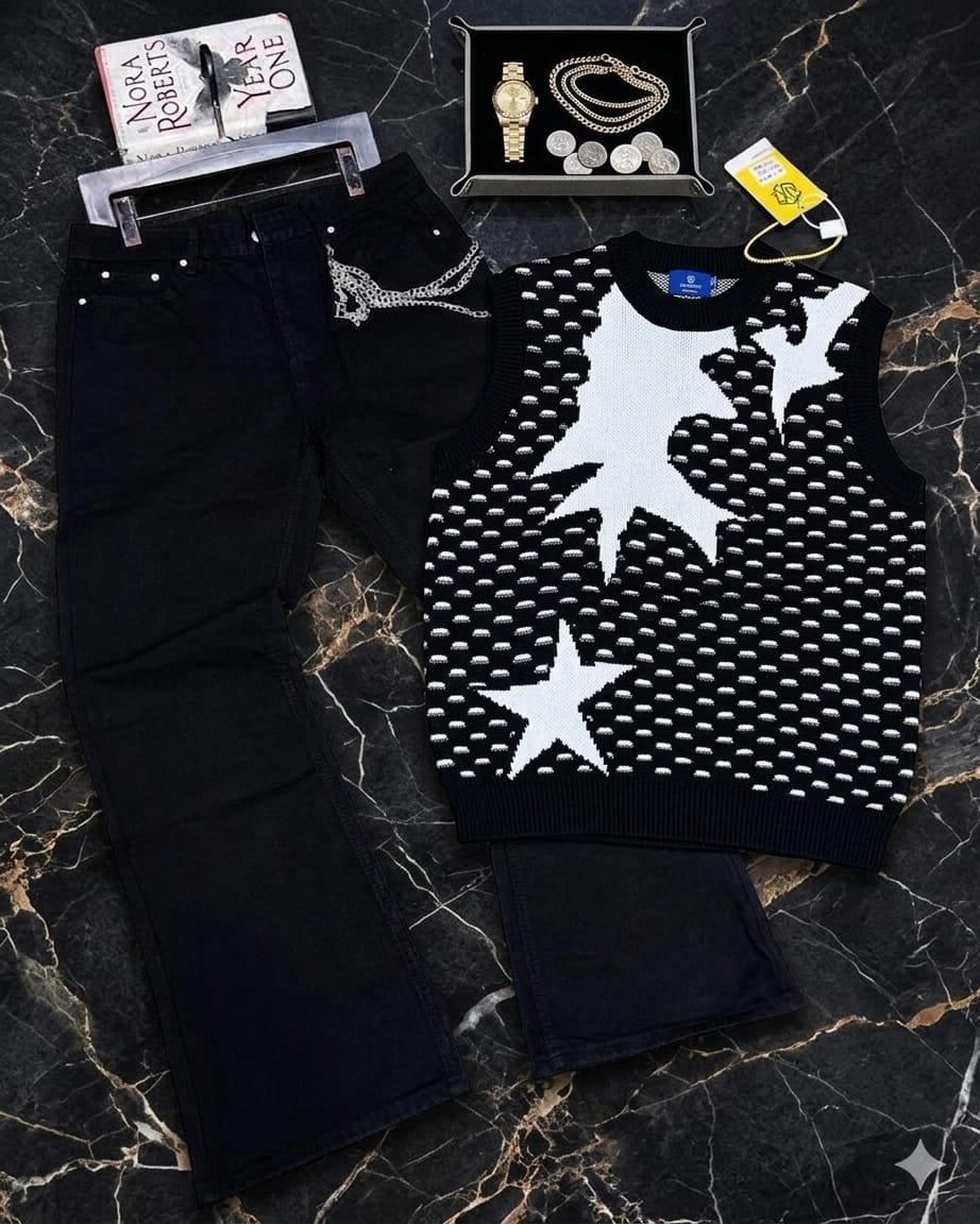 Black star pattern sleeveless knit vest paired with black pants and accessories on marble surface.