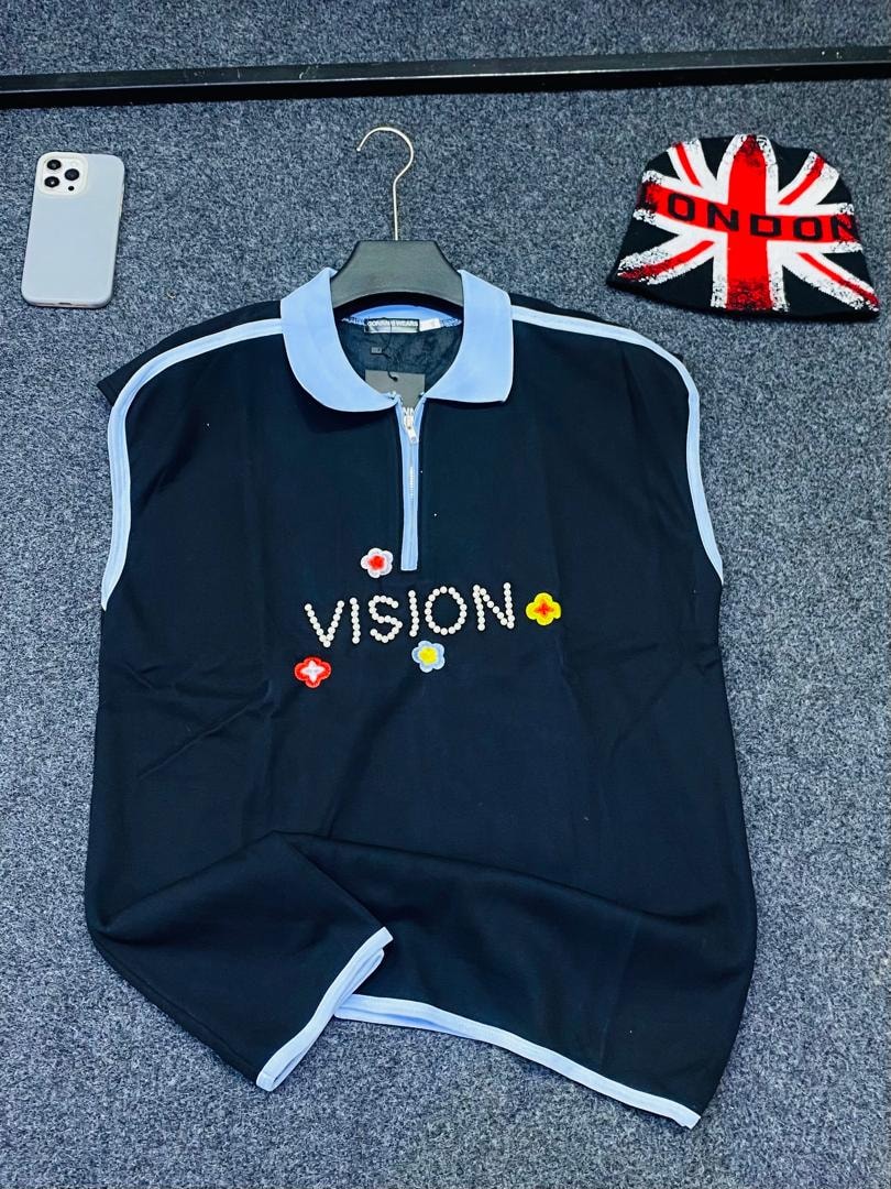 Black armless quarter-zip polo with VISION beaded text and flower embroidery.