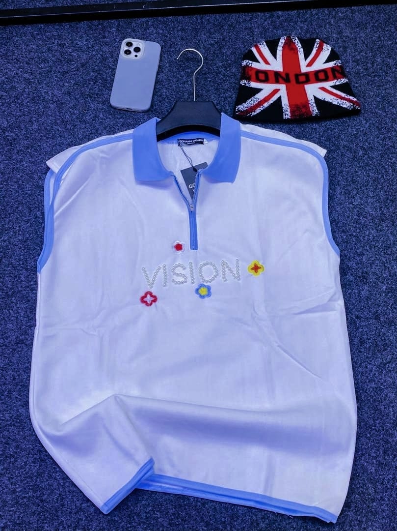 White armless quarter-zip polo with VISION beaded text and flower embroidery.