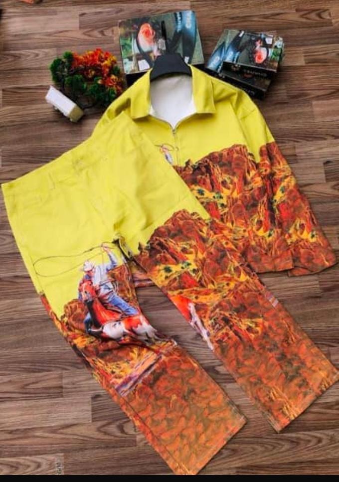 Yellow and orange flame print zip top and pants two-piece set on wooden floor.
