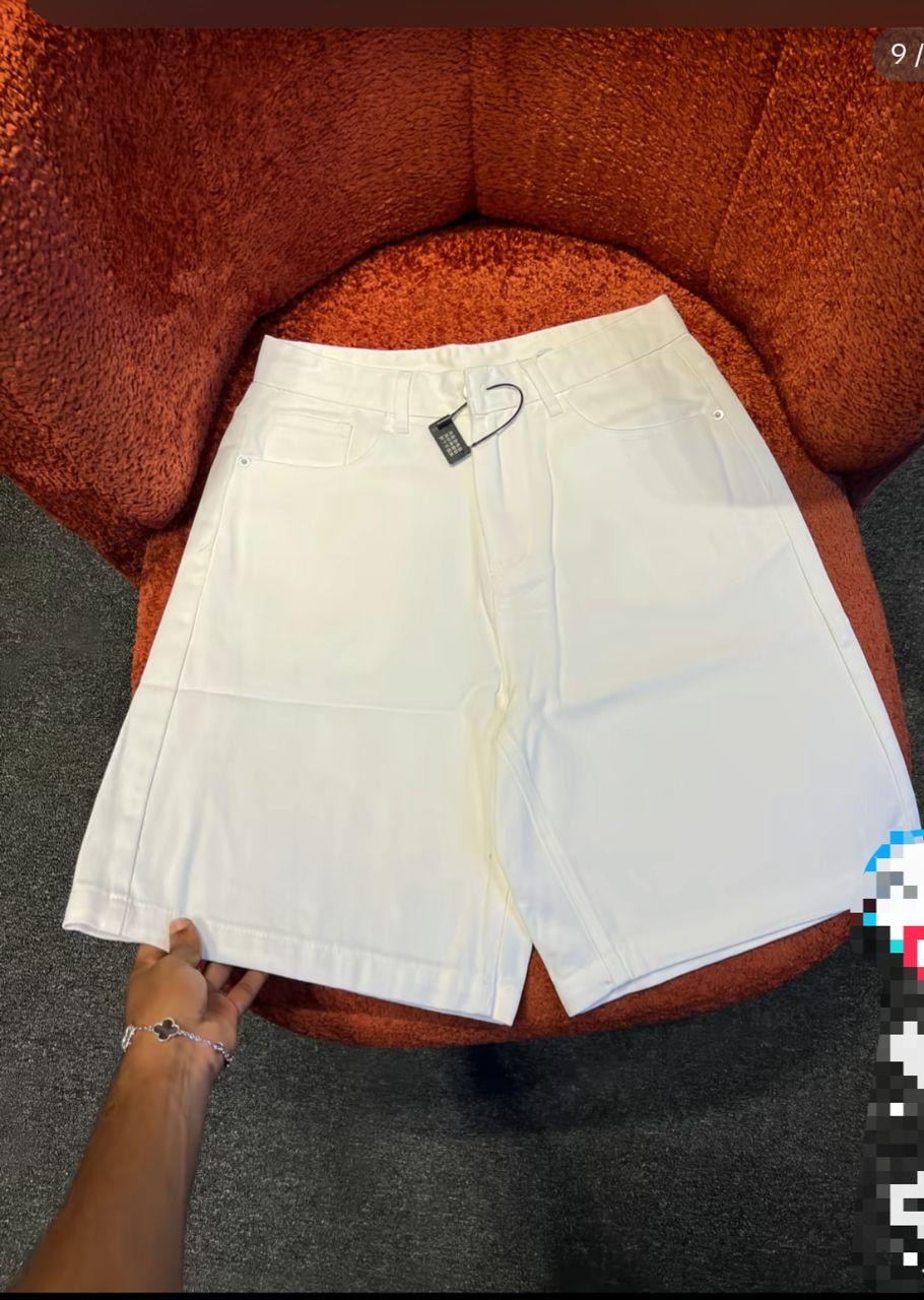 Front view of plain white baggy jean shorts displayed on an orange chair.