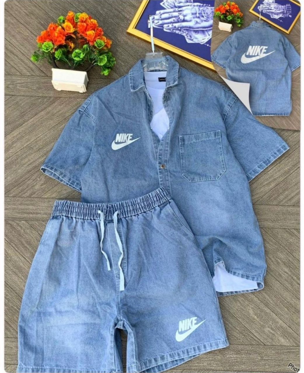 Light blue Nike denim short-sleeve shirt with chest pocket and matching shorts featuring white swoosh logos.