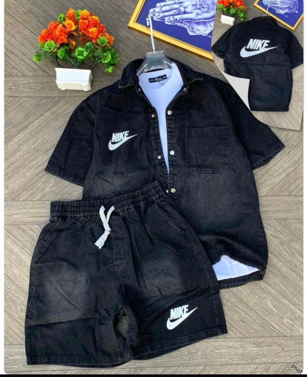 Black Nike denim short-sleeve shirt with chest pocket and matching shorts featuring white swoosh logos.