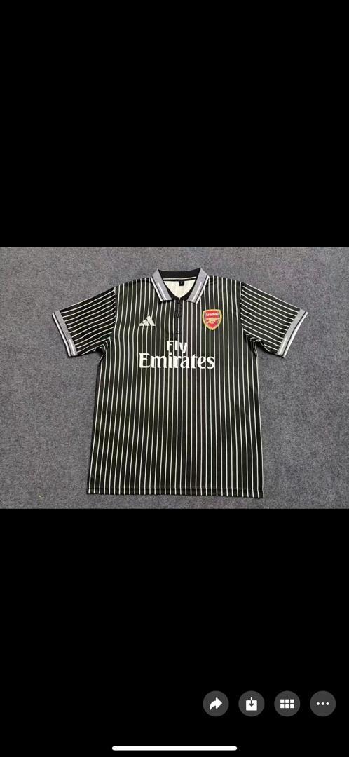 Black and white striped Adidas Arsenal Fly Emirates polo shirt laid flat.