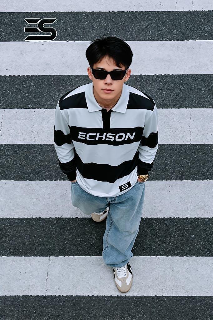 Model wearing black and white striped long sleeve polo with ECHSON chest print.
