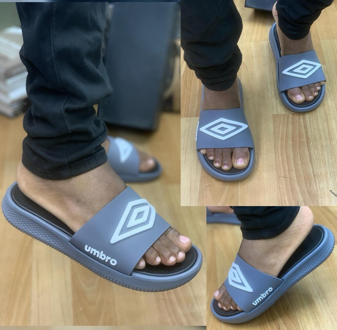Gray Umbro slides worn on feet with close-up views of the logo and sole.