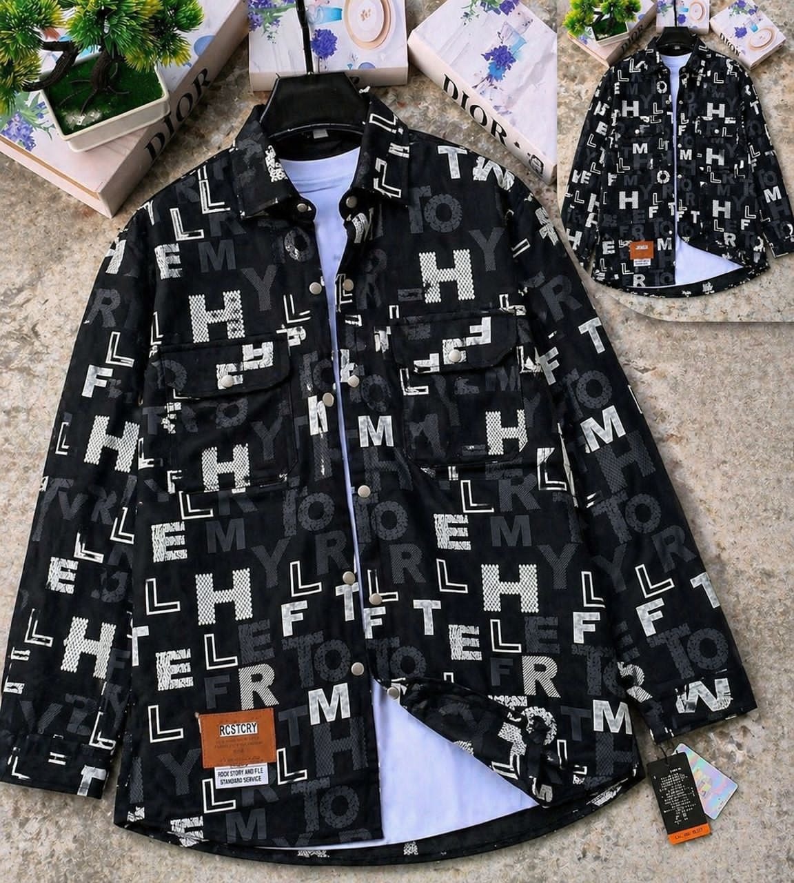 Black letter and symbol patterned denim jacket on display with white inner shirt and inset view.