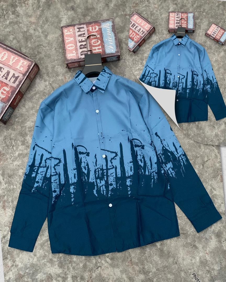 Light blue to dark blue cityscape print shirt displayed with props.