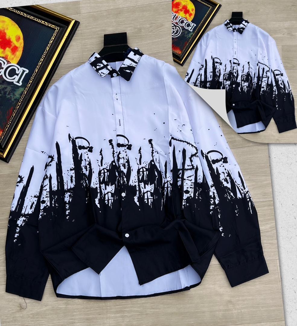 White and black cityscape splatter print button down shirt on wooden floor.
