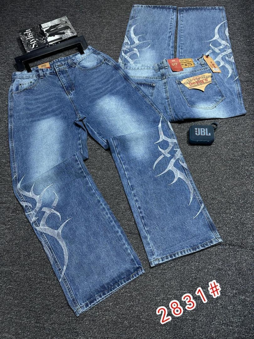 Blue baggy jeans with white flame embroidery shown flat with back details and tags.
