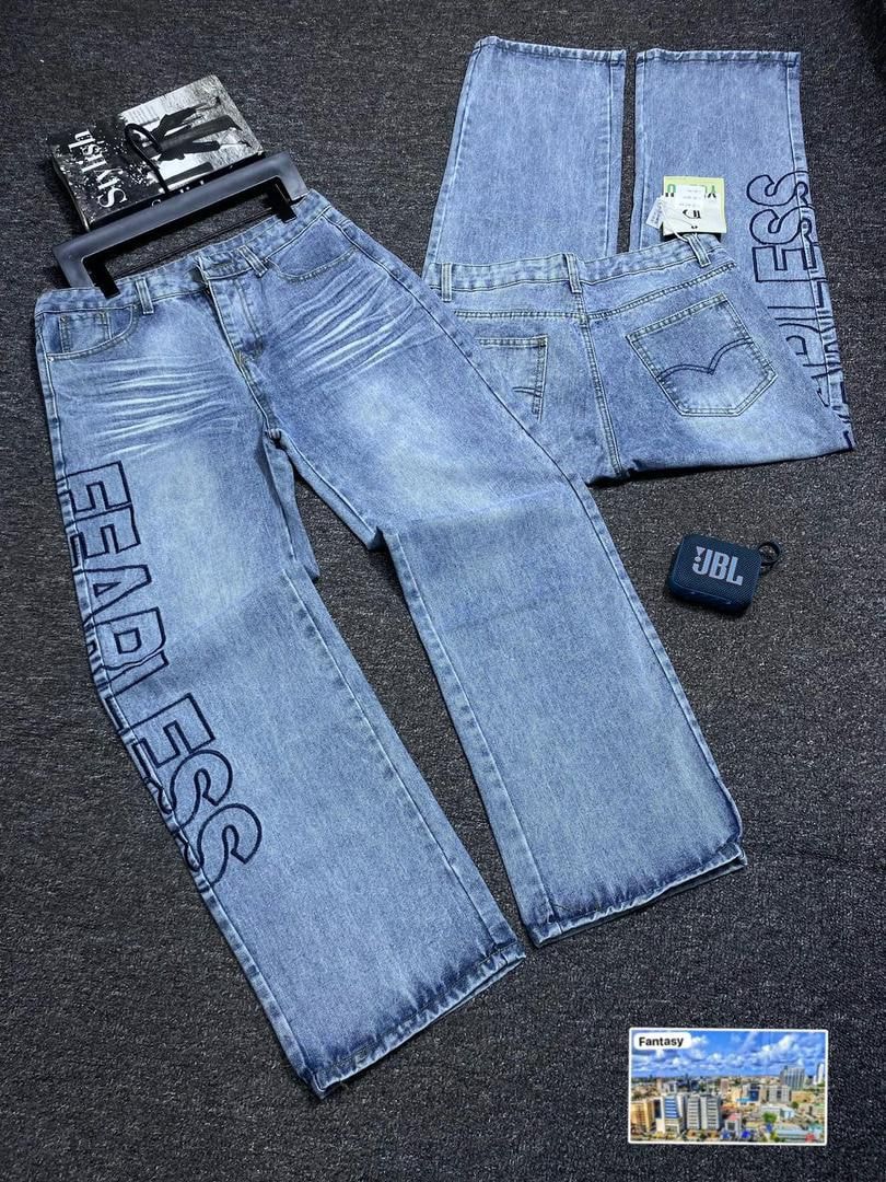 Light blue baggy jeans with large FEARLESS text printed down the leg, flat lay with front and back views.
