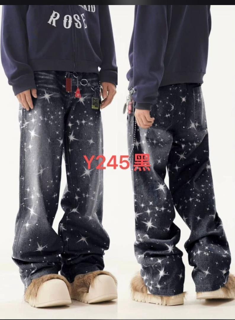 Front and back views of dark star-printed baggy jeans worn with navy sweatshirt and fuzzy slides.