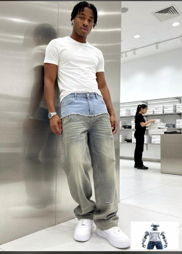 Man modeling two-tone light blue and gray baggy jeans with white t-shirt and sneakers.
