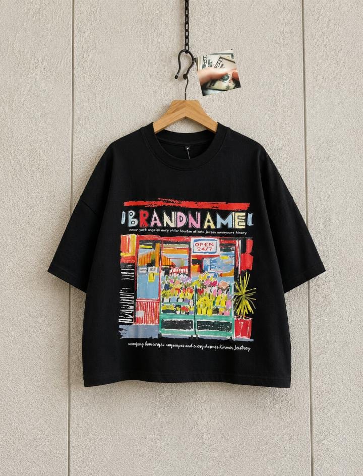 Black cropped tee hanging displaying colorful storefront Brandname graphic.