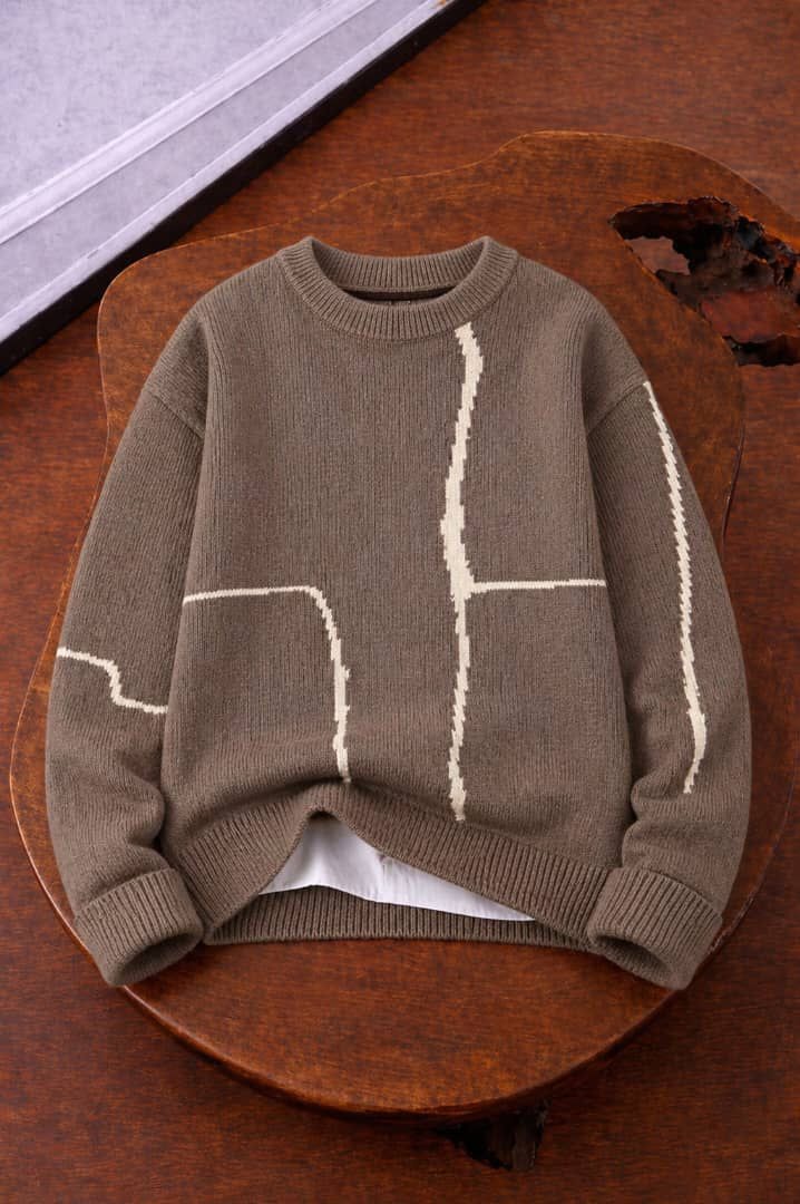 Brown knit sweater with white geometric line patterns on body and sleeves.