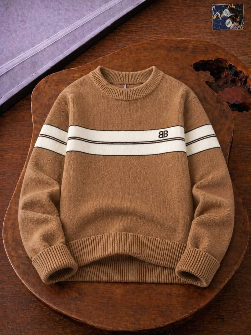 Brown knit sweater with white stripes on sleeves and BB logo on wooden table.