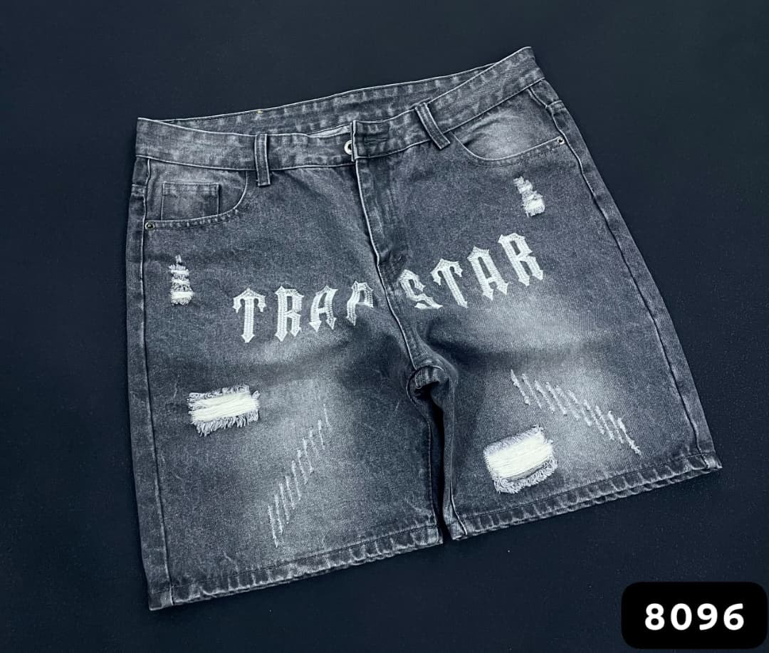 Gray washed denim shorts with white TRAPSTAR print and multiple rips.