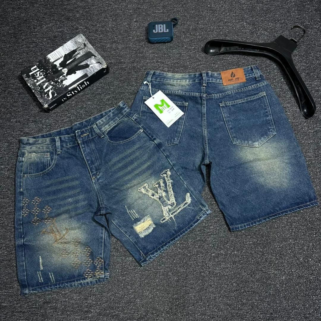 Blue denim shorts with LV-inspired embroidery, monogram patterns and distressed rips.