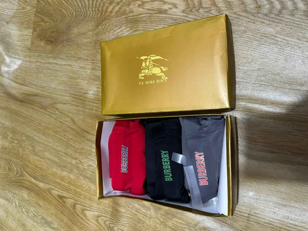 Gold Burberry box with red, black, and gray Burberry boxer briefs.
