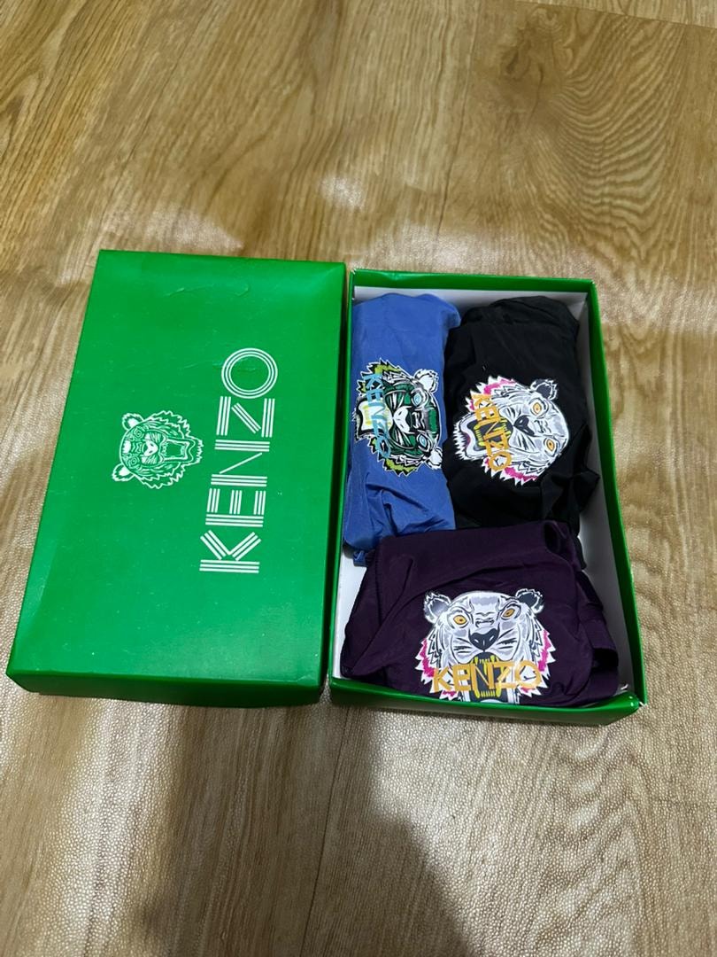 Green Kenzo box containing blue, black, and purple tiger logo boxers.