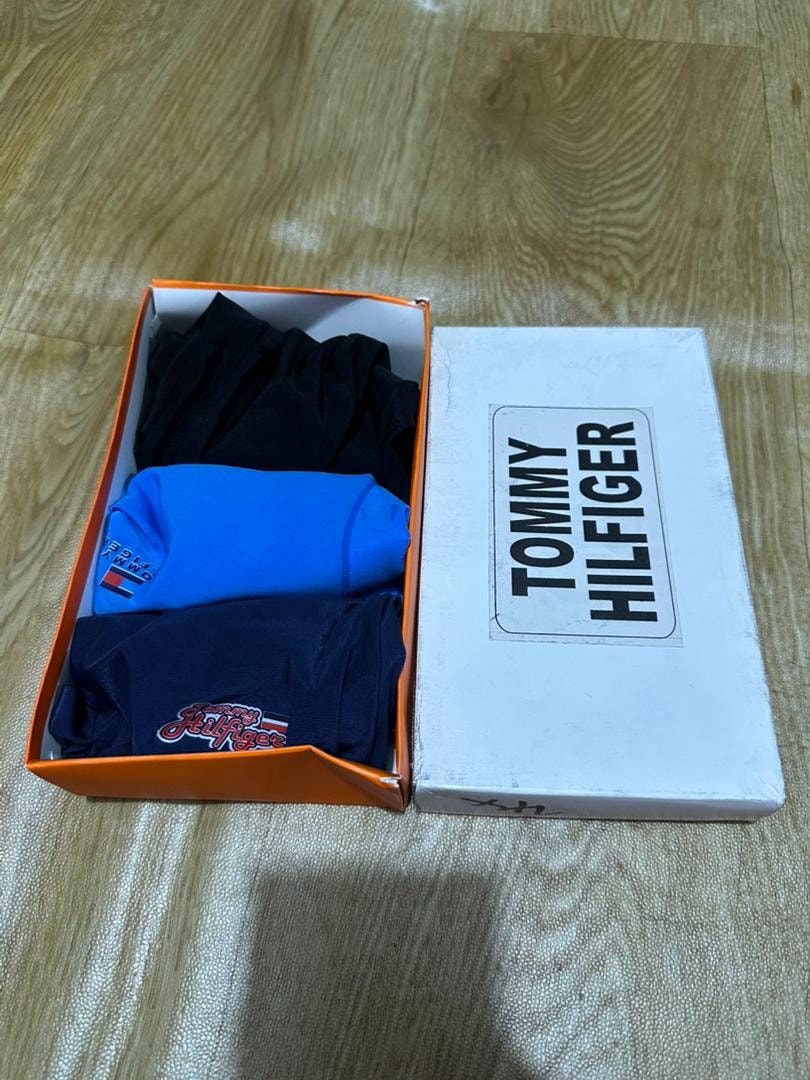 Orange Tommy Hilfiger box with black, blue, and navy boxer briefs.
