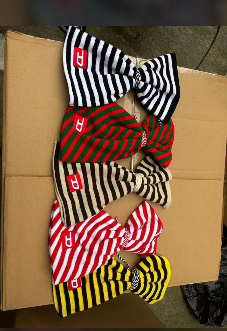 Assortment of five striped head warmers in black/white, red/green, brown/beige, red/white and yellow/black, each with red P logo patch.