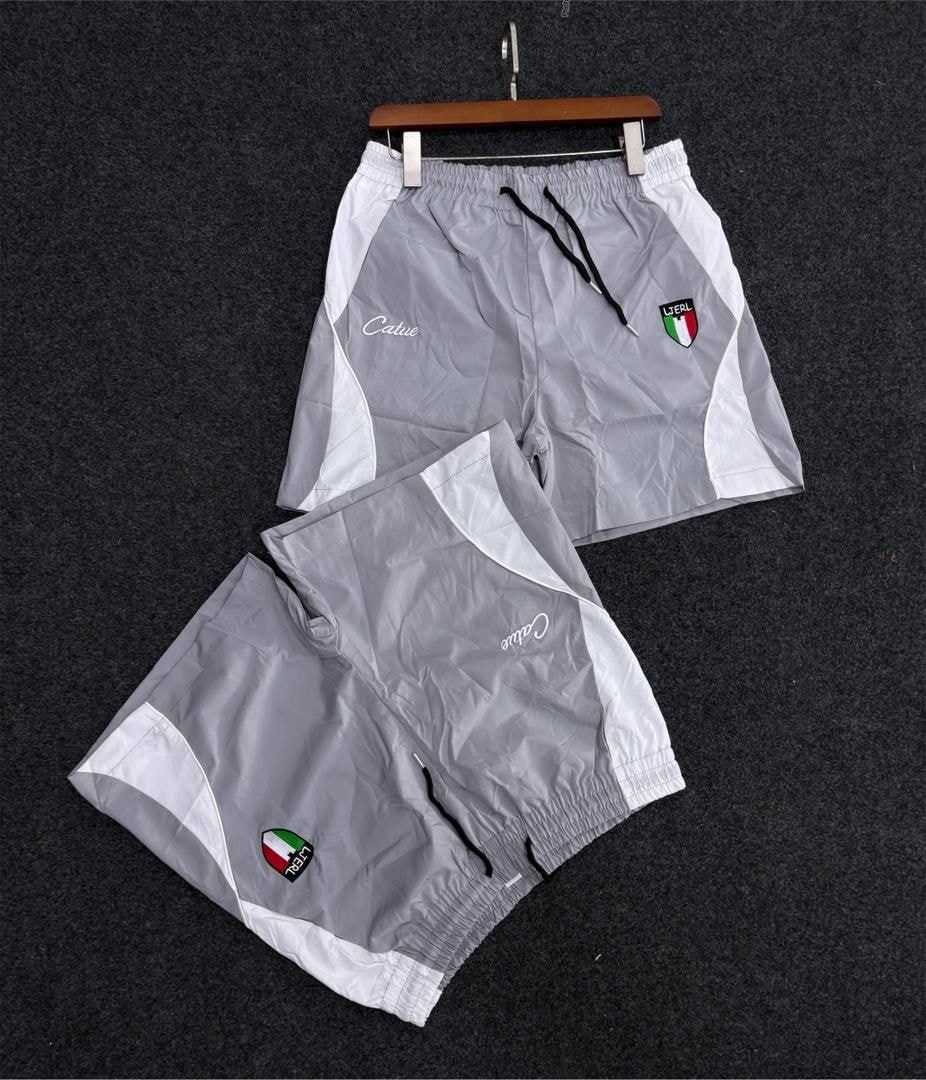 Gray and white colorblock track shorts with script logo and Italian flag patch.